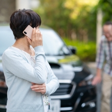 交通事故に遭い電話を掛ける女性の写真